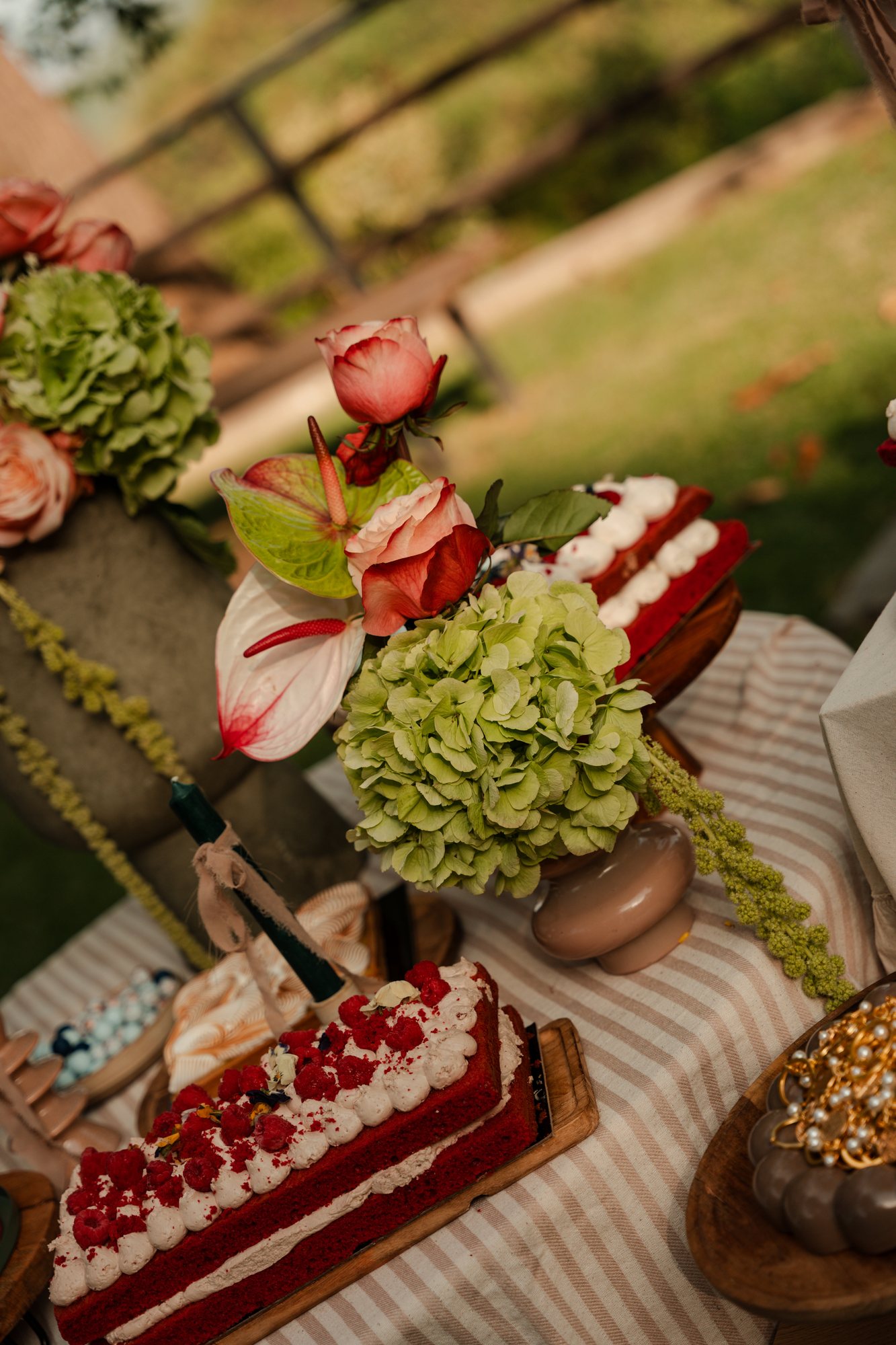 Red velvet cake among hydrangeas and roses on the dessert table