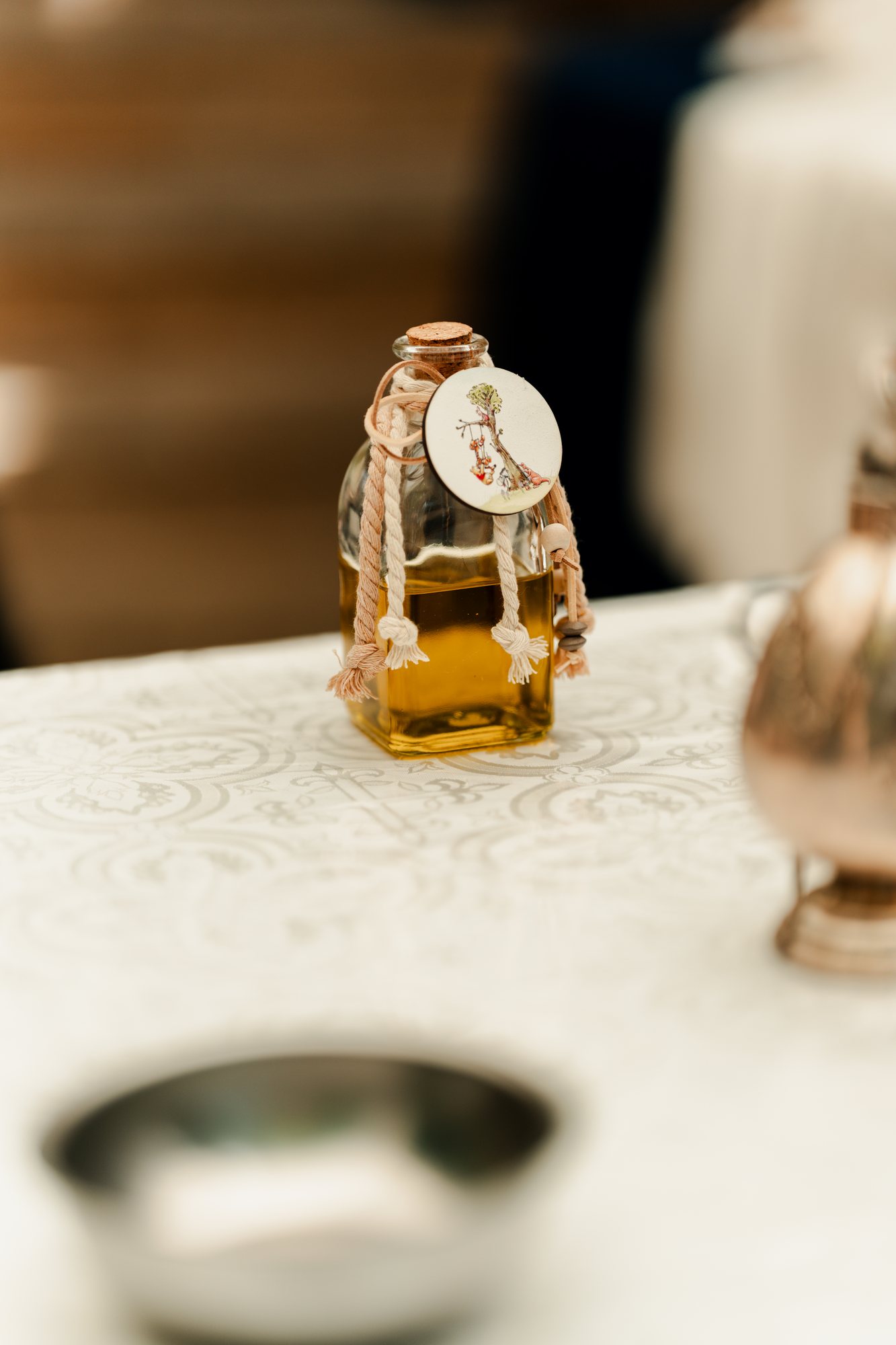 A small bottle of holy oil tied with a tag on the ceremony table