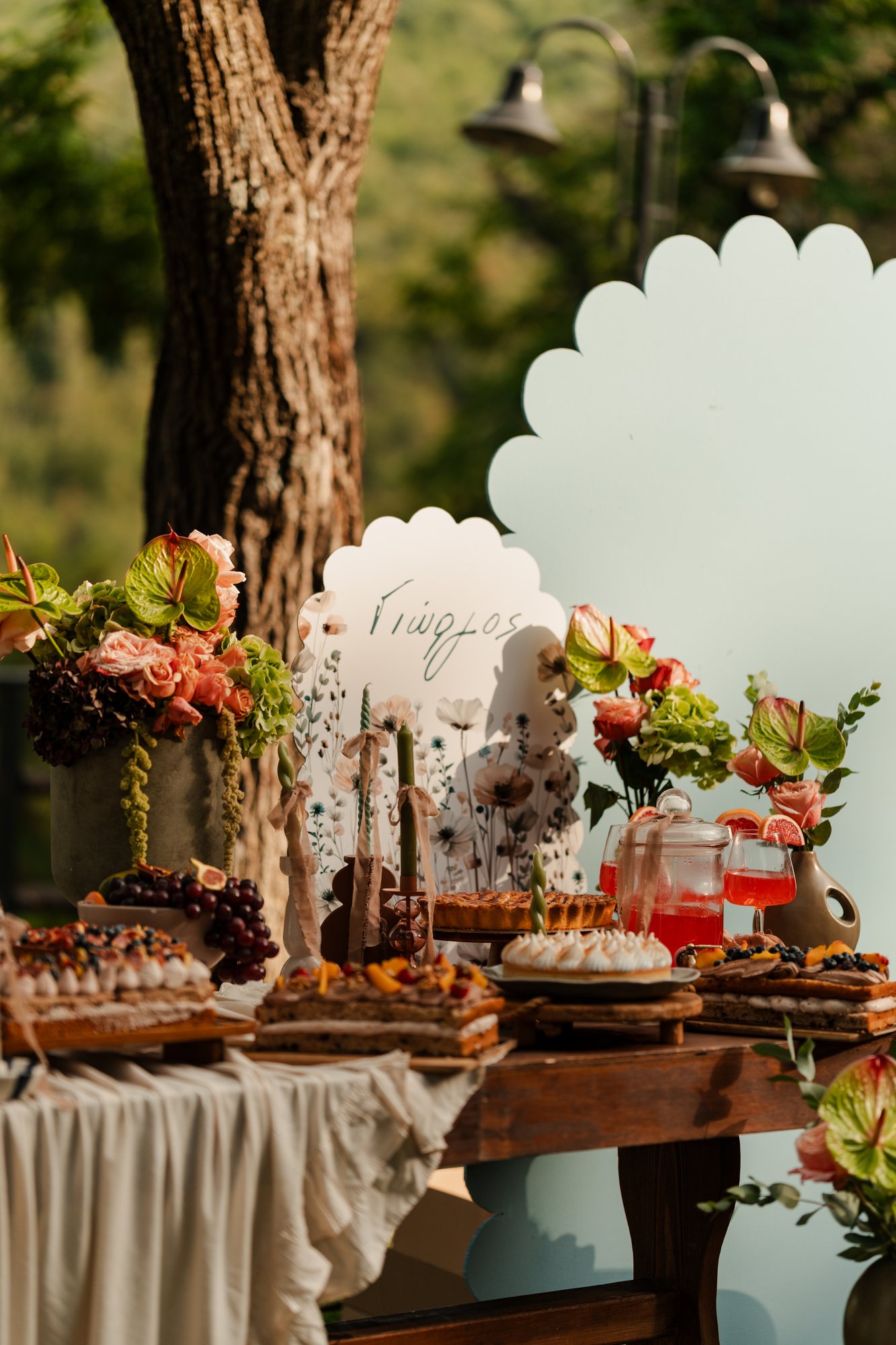 Dessert table with a scalloped backdrop, flowers and a welcome sign
