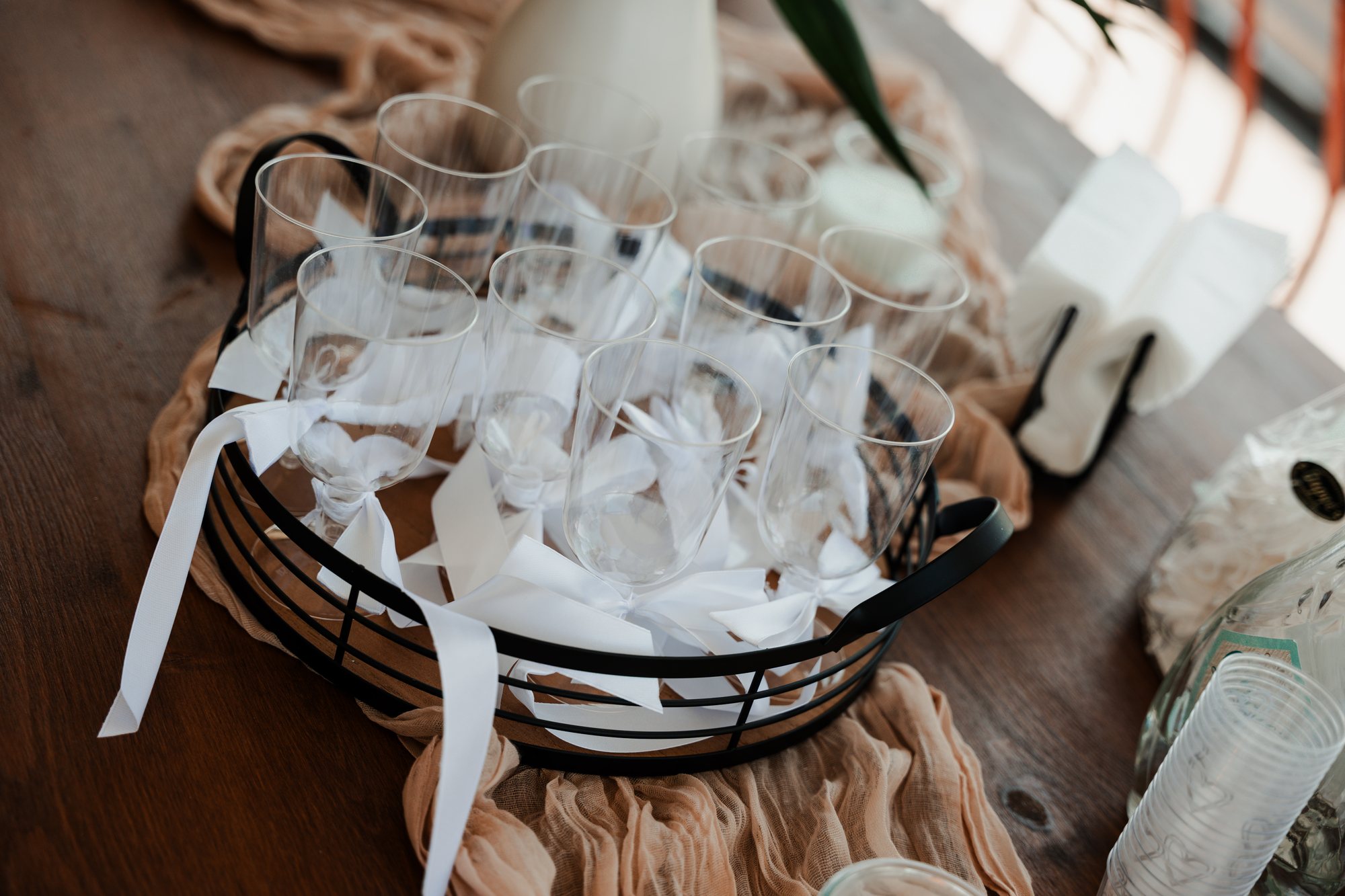 A basket of glasses tied with white ribbons on the reception table