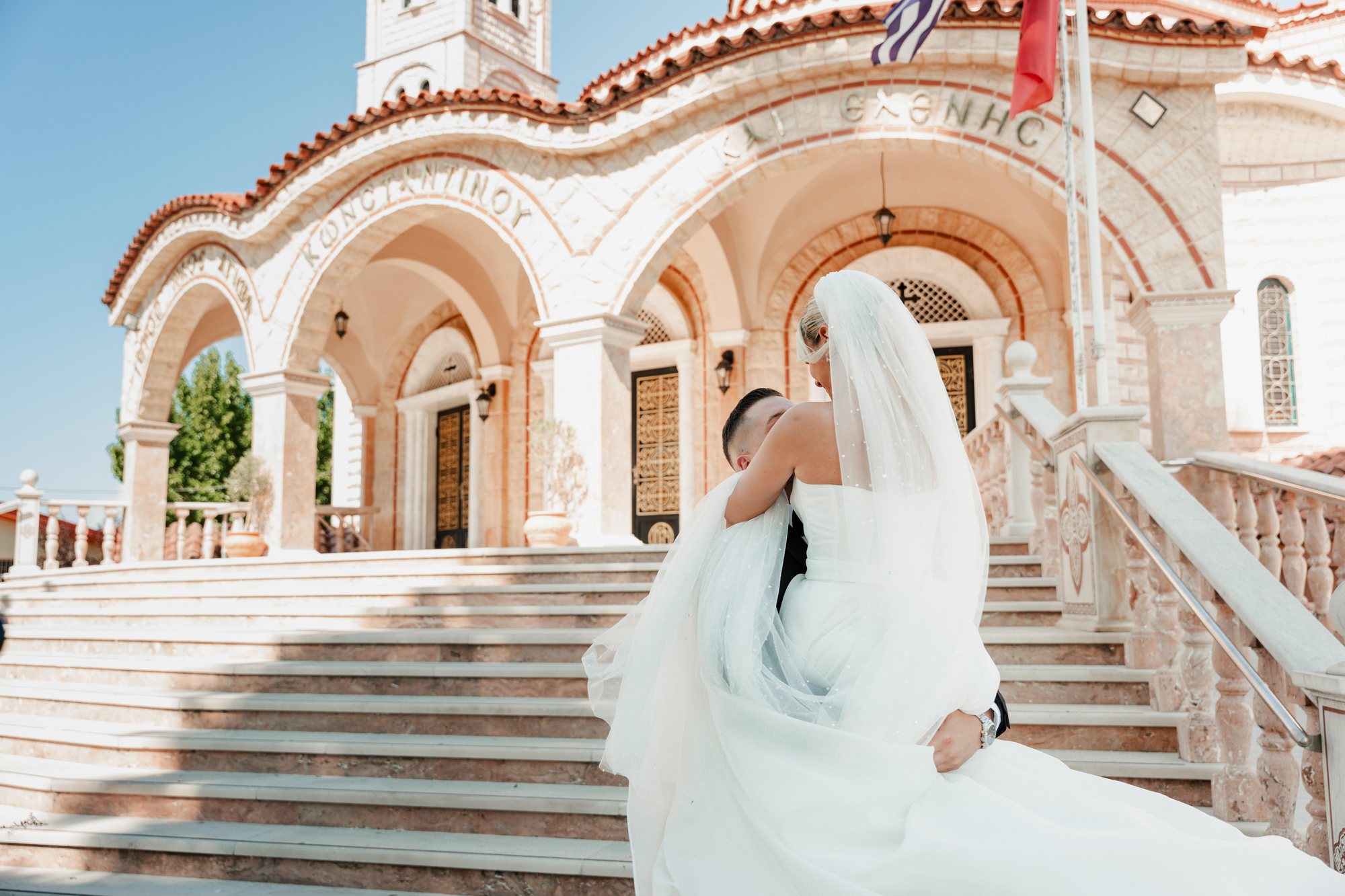 Bride and groom embrace on the church steps