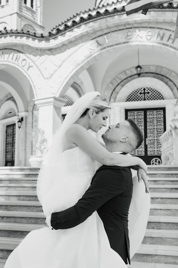 Black and white photo of the groom lifting the bride in a quiet embrace
