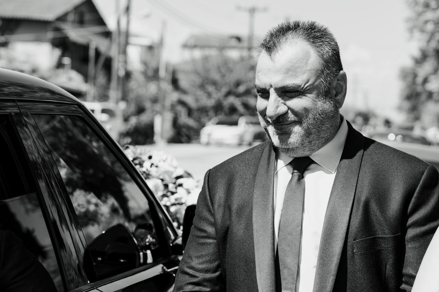 Black and white portrait of a family member waiting by the car