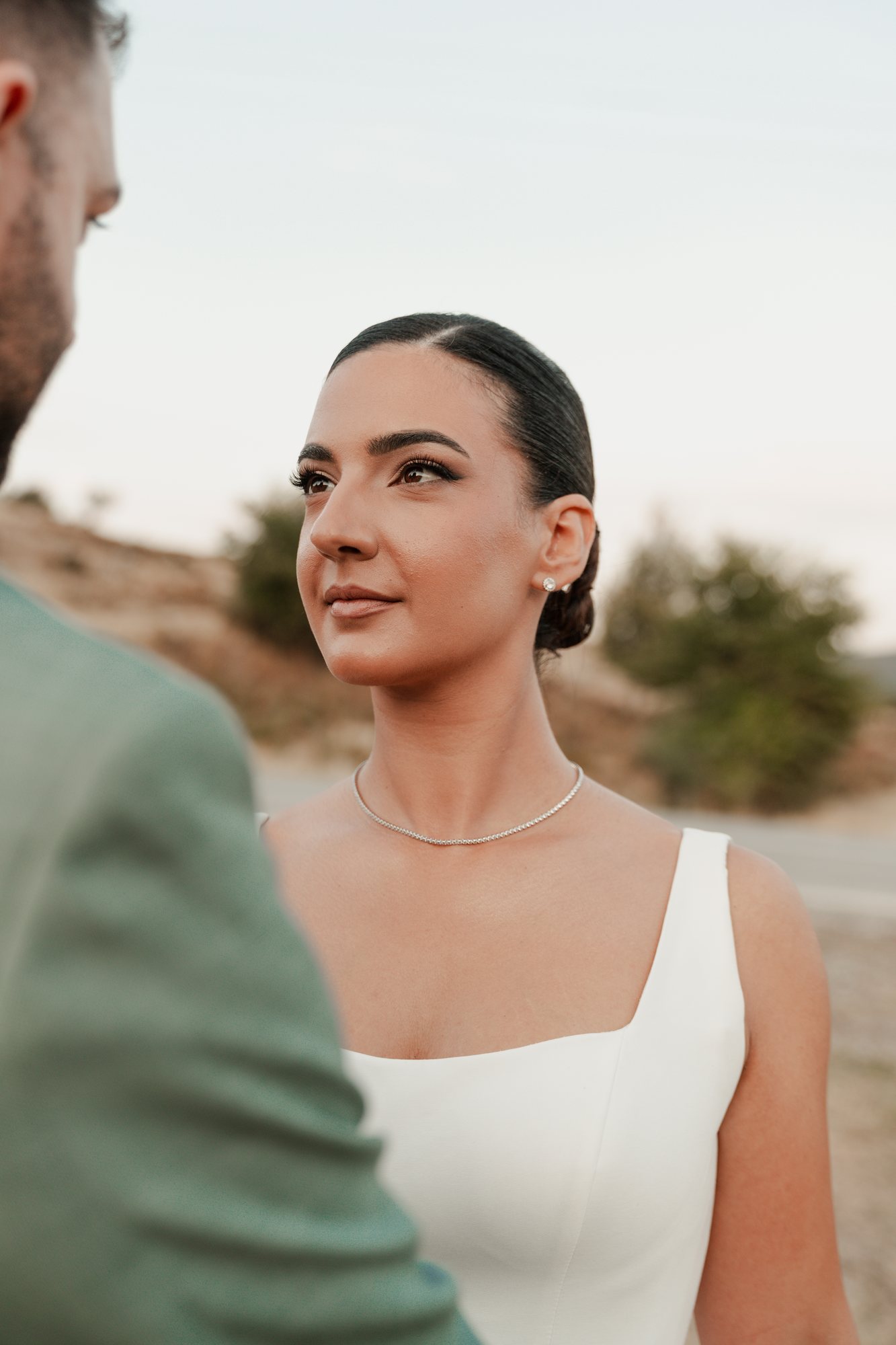 The bride looks up at the groom at sunset