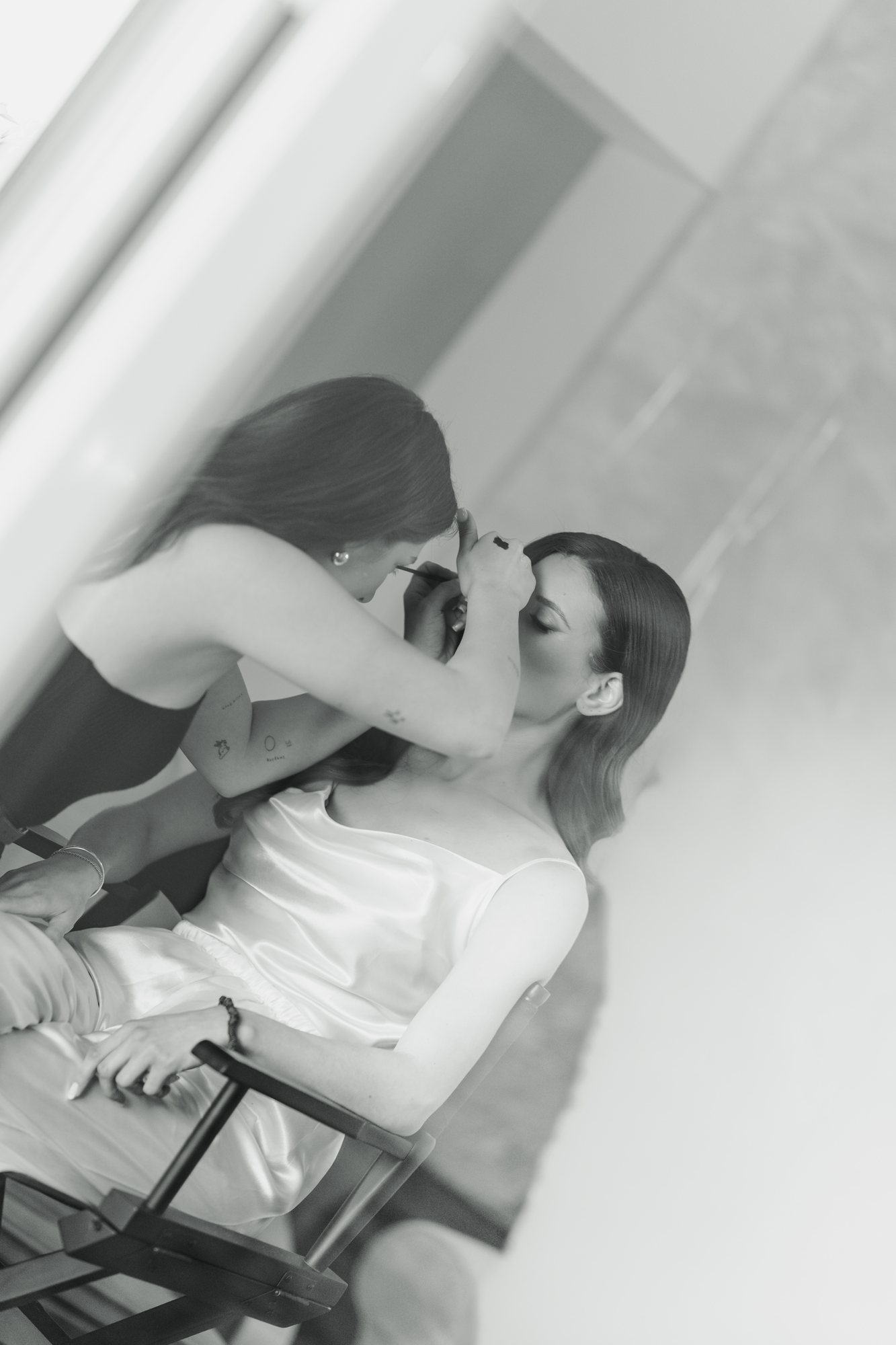 Black and white photo of a make-up artist applying the bride’s lipstick